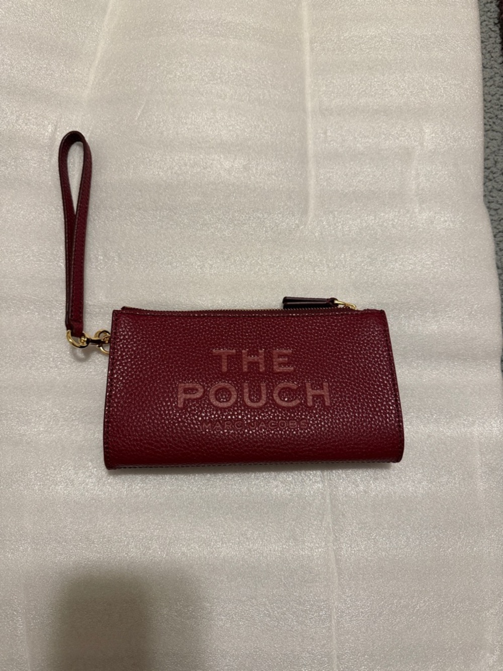 Marc Jacobs The Pouch Wristlet in the color cherry.